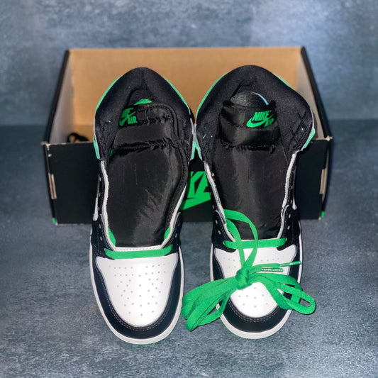 White, green, and black Nike Air Jordan 1 Retro High grade school sneakers with a black and green Nike Air Jordan sneaker box.