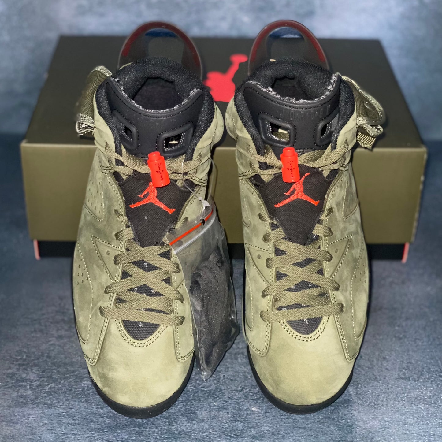 Military green Air Jordan 6 Travis Scott sneakers with a green and black Air Jordan Travis Scott sneaker box.