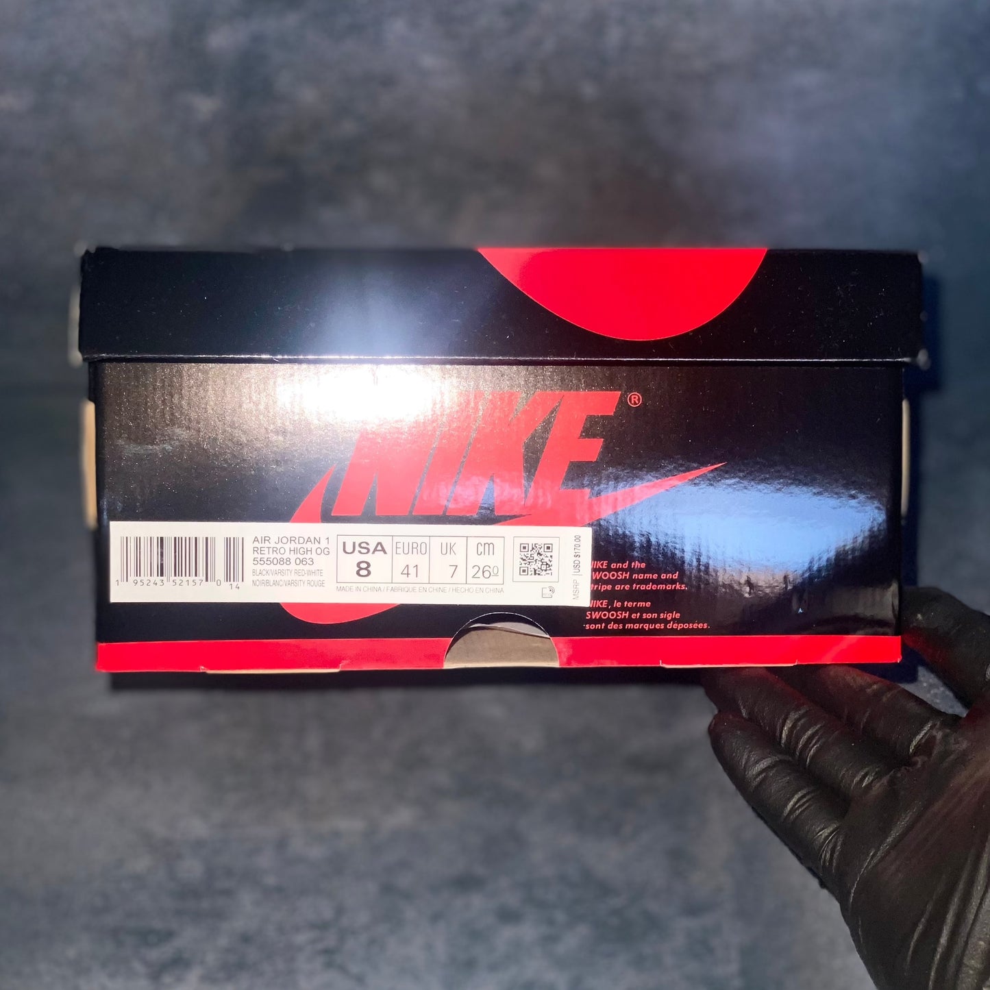 Black and red Nike Air Jordan 1 Retro High sneaker box with the barcode, style code, size, and other sneaker information on a label.