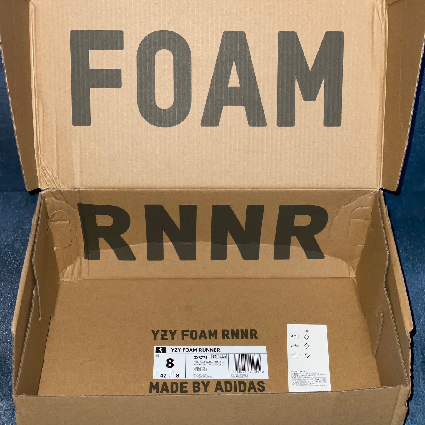 The brown open sneaker box for the Yeezy Foam Runner Cream Clay sneakers with the barcode, style code, size, and other sneaker information on a label.